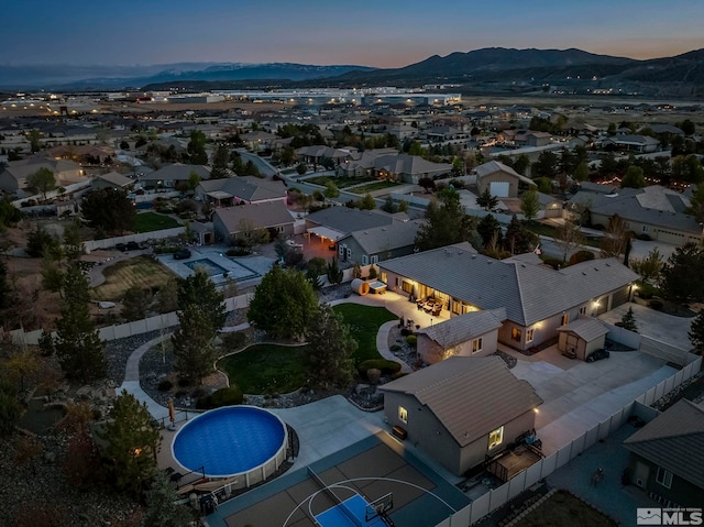 aerial view at dusk with a mountain view and a residential view