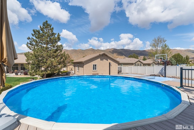 view of swimming pool with fence, a fenced in pool, and a mountain view