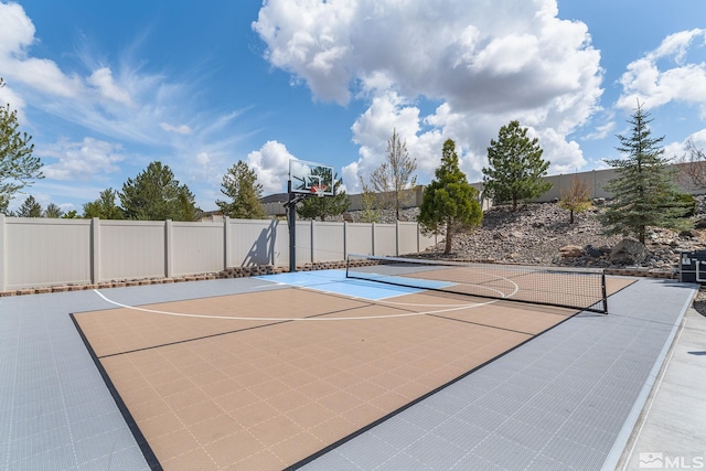 view of basketball court with fence and basketball hoop