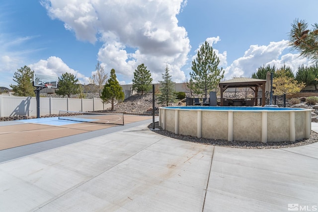 surrounding community featuring a swimming pool, a gazebo, and fence