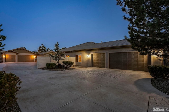 ranch-style house featuring a garage, fence, and concrete driveway