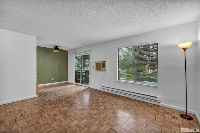 unfurnished living room with ceiling fan, a textured ceiling, baseboards, a baseboard heating unit, and an AC wall unit