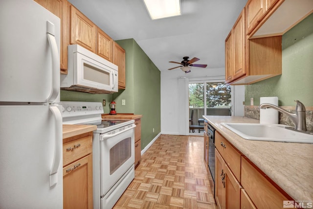 kitchen with baseboards, a sink, a ceiling fan, and white appliances
