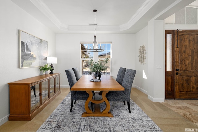 dining area featuring an inviting chandelier, baseboards, a tray ceiling, and light colored carpet