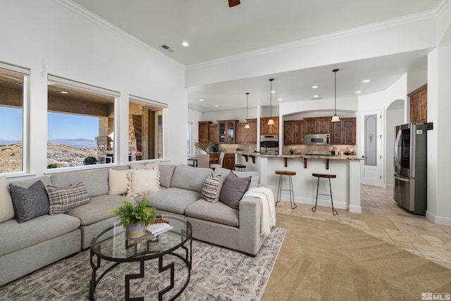living room featuring crown molding, visible vents, stone tile flooring, baseboards, and recessed lighting