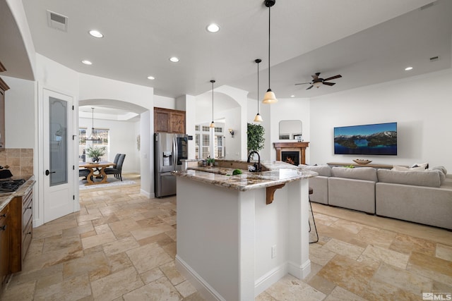 kitchen featuring visible vents, stone tile flooring, open floor plan, stainless steel appliances, and recessed lighting
