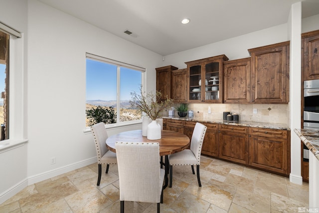 dining area featuring visible vents, baseboards, a mountain view, recessed lighting, and stone tile floors