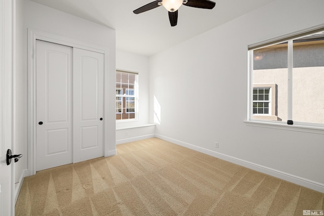 unfurnished bedroom featuring carpet floors, baseboards, ceiling fan, and a closet