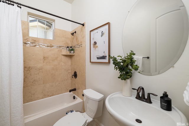 full bath featuring toilet, shower / bath combination with curtain, and a sink