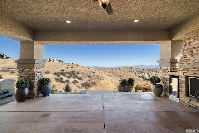 view of patio with an outdoor stone fireplace and a mountain view