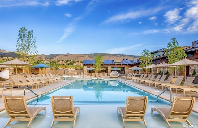 pool featuring a patio, a mountain view, and fence