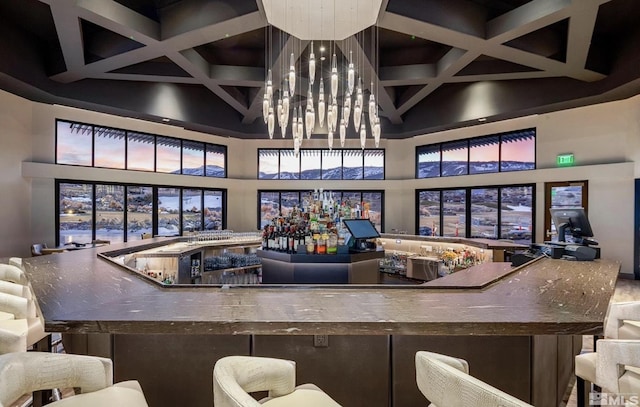 bar with a high ceiling, beamed ceiling, coffered ceiling, and wet bar