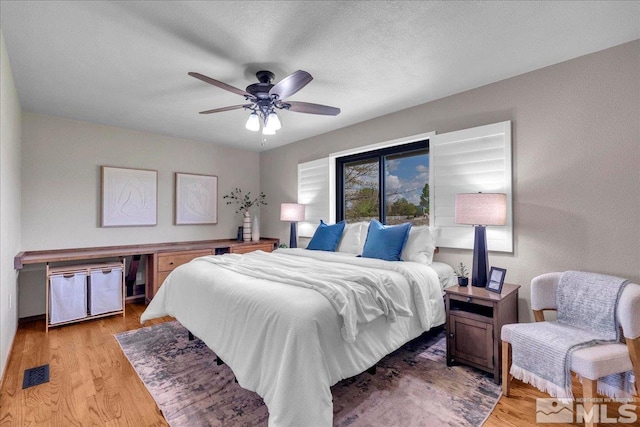 bedroom with visible vents, light wood finished floors, and ceiling fan