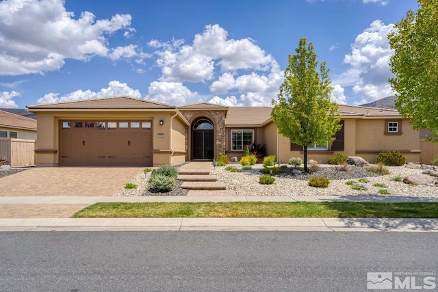 view of front of home with a tiled roof, an attached garage, driveway, and stucco siding