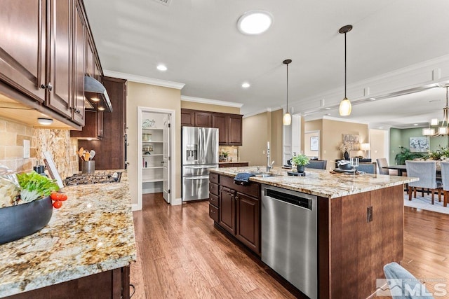 kitchen with dark brown cabinetry, appliances with stainless steel finishes, ornamental molding, and a sink