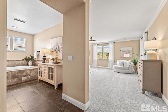 corridor featuring dark tile patterned flooring, baseboards, and visible vents