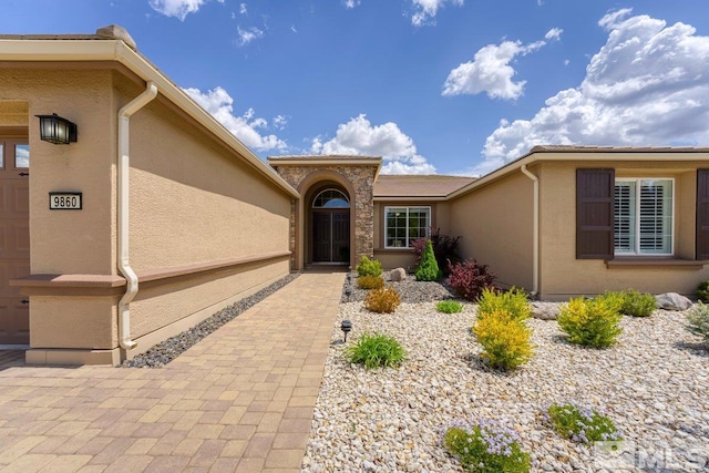 view of exterior entry with stucco siding