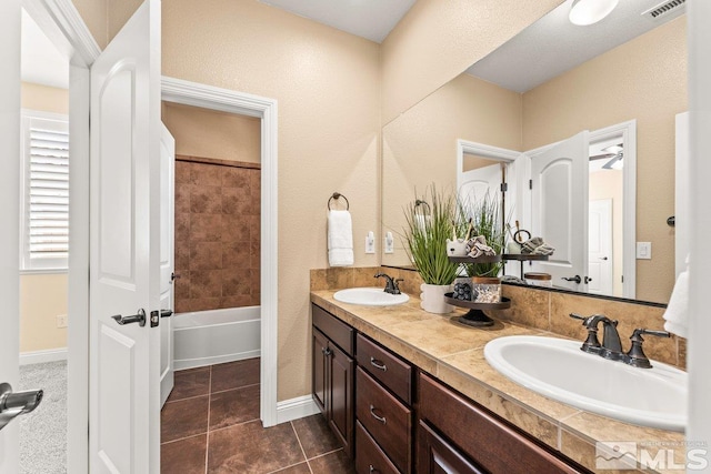 full bath with double vanity, tile patterned floors, visible vents, and a sink