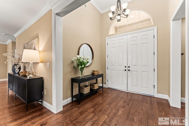 foyer featuring crown molding, baseboards, a chandelier, and wood finished floors