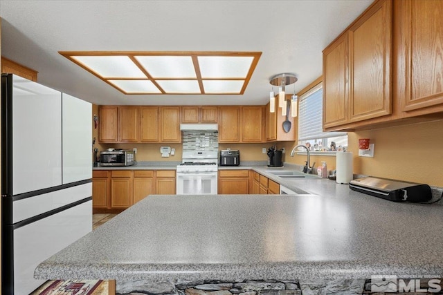 kitchen featuring a sink, light countertops, under cabinet range hood, and white appliances