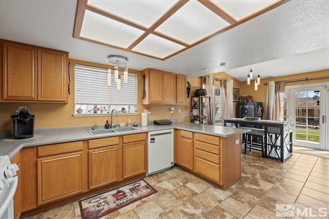 kitchen with white dishwasher, stove, a sink, light countertops, and a peninsula