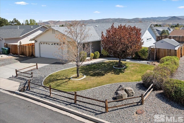 ranch-style house with fence, an attached garage, a front lawn, a mountain view, and concrete driveway