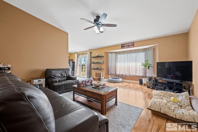 living room featuring ceiling fan, vaulted ceiling, and wood finished floors