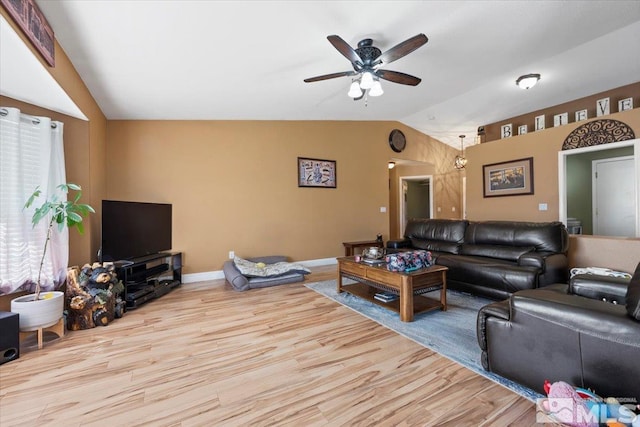 living room featuring ceiling fan, visible vents, vaulted ceiling, wood finished floors, and baseboards