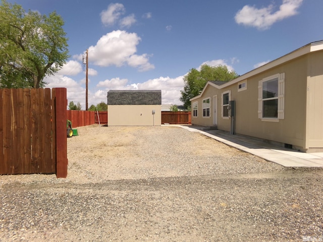 view of yard featuring a storage shed, an outdoor structure, and a fenced backyard