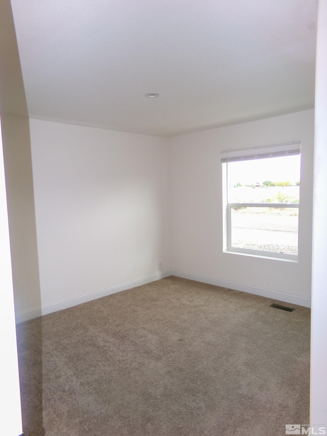 spare room featuring baseboards, carpet flooring, and visible vents