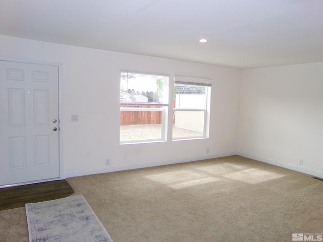 carpeted spare room featuring baseboards and recessed lighting