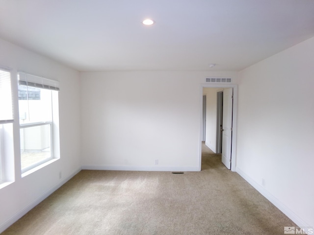 spare room featuring recessed lighting, baseboards, visible vents, and light carpet