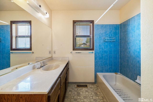 bathroom featuring tile patterned flooring, vanity, shower / bath combination, baseboards, and visible vents