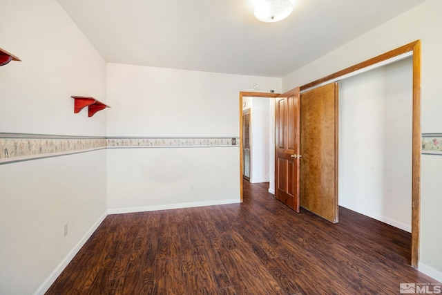 unfurnished bedroom featuring dark wood-type flooring, baseboards, and a closet