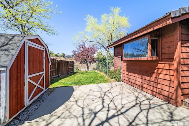 view of patio featuring fence, a storage unit, and an outdoor structure