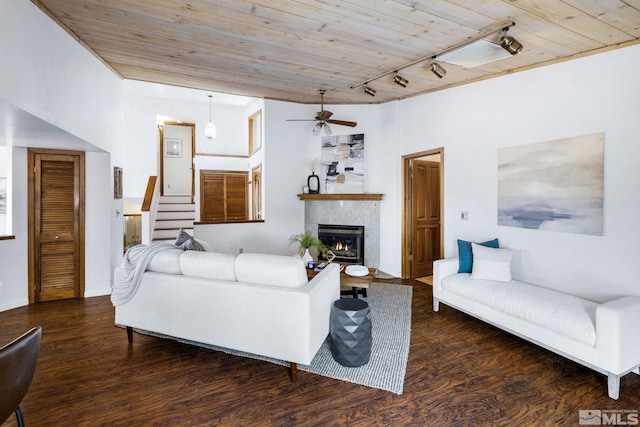 living area with stairs, track lighting, wood finished floors, and wooden ceiling