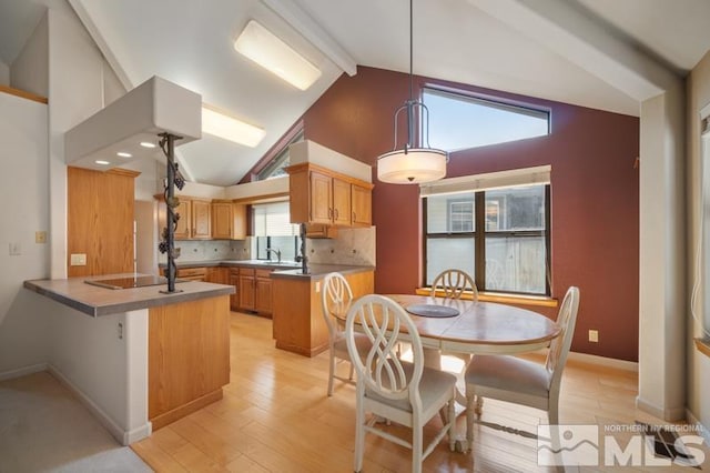 kitchen featuring backsplash, black electric cooktop, light wood finished floors, a peninsula, and vaulted ceiling with beams