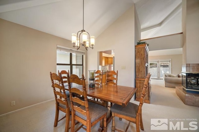 dining area with high vaulted ceiling, baseboards, a notable chandelier, and light colored carpet