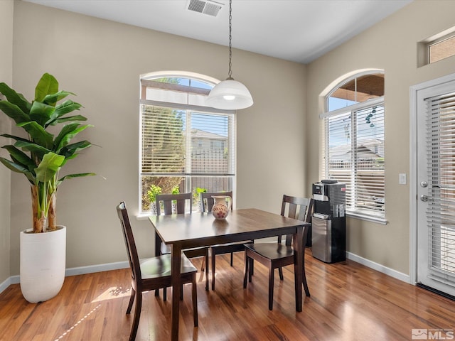dining space with baseboards, wood finished floors, and visible vents