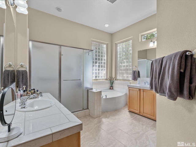 full bath with a sink, a bath, two vanities, and a shower stall