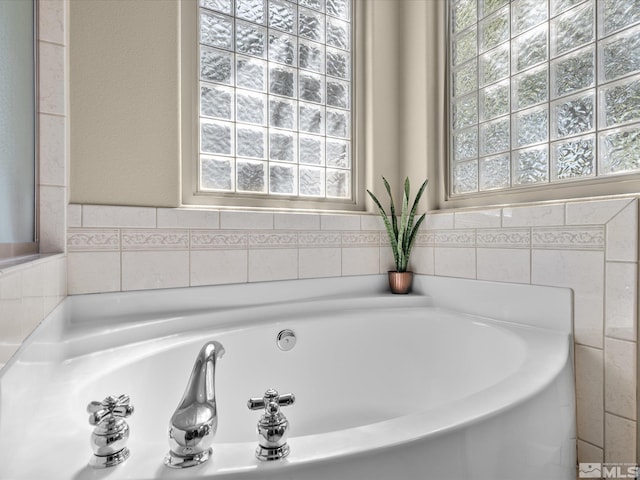 full bath with a garden tub and a healthy amount of sunlight