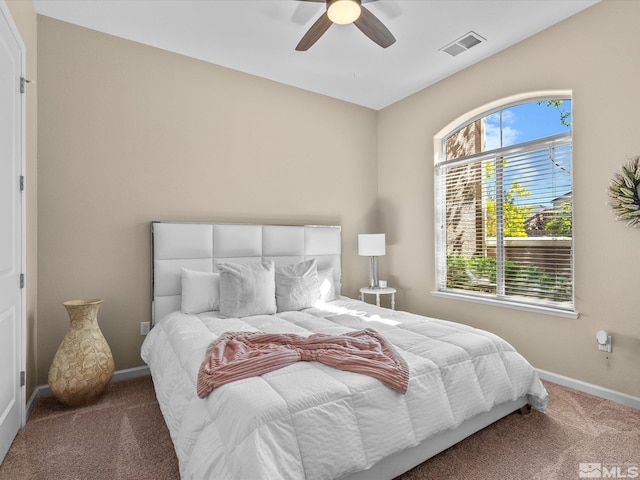 carpeted bedroom featuring baseboards, ceiling fan, and visible vents