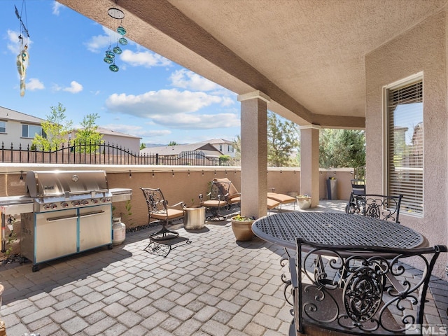 view of patio featuring fence and a grill