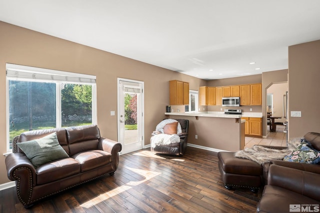 living area with recessed lighting, baseboards, and light wood-type flooring