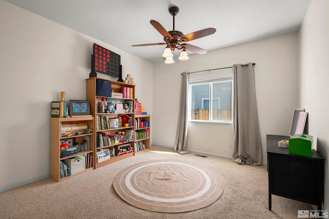 interior space with baseboards, a ceiling fan, and carpet