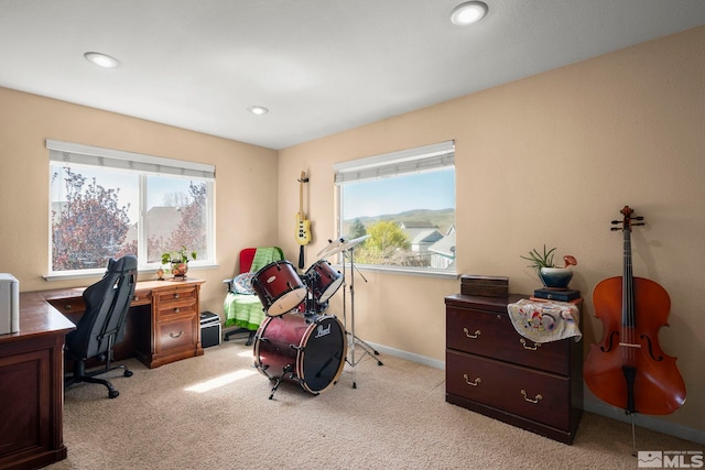 office space featuring plenty of natural light, recessed lighting, and light carpet