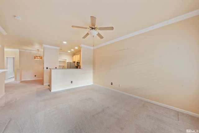 spare room featuring crown molding, baseboards, light carpet, and ceiling fan with notable chandelier