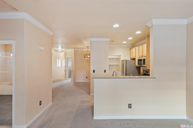 kitchen featuring crown molding, appliances with stainless steel finishes, a sink, baseboards, and light brown cabinets