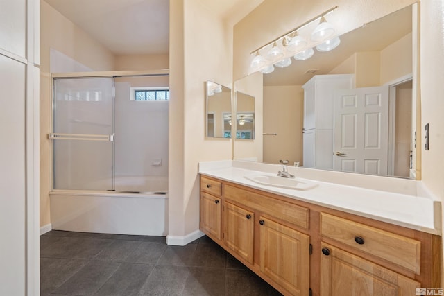 bathroom featuring vanity, baseboards, combined bath / shower with glass door, and tile patterned floors