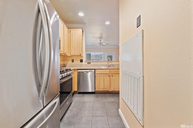 kitchen with light brown cabinetry, appliances with stainless steel finishes, a sink, light countertops, and light tile patterned floors